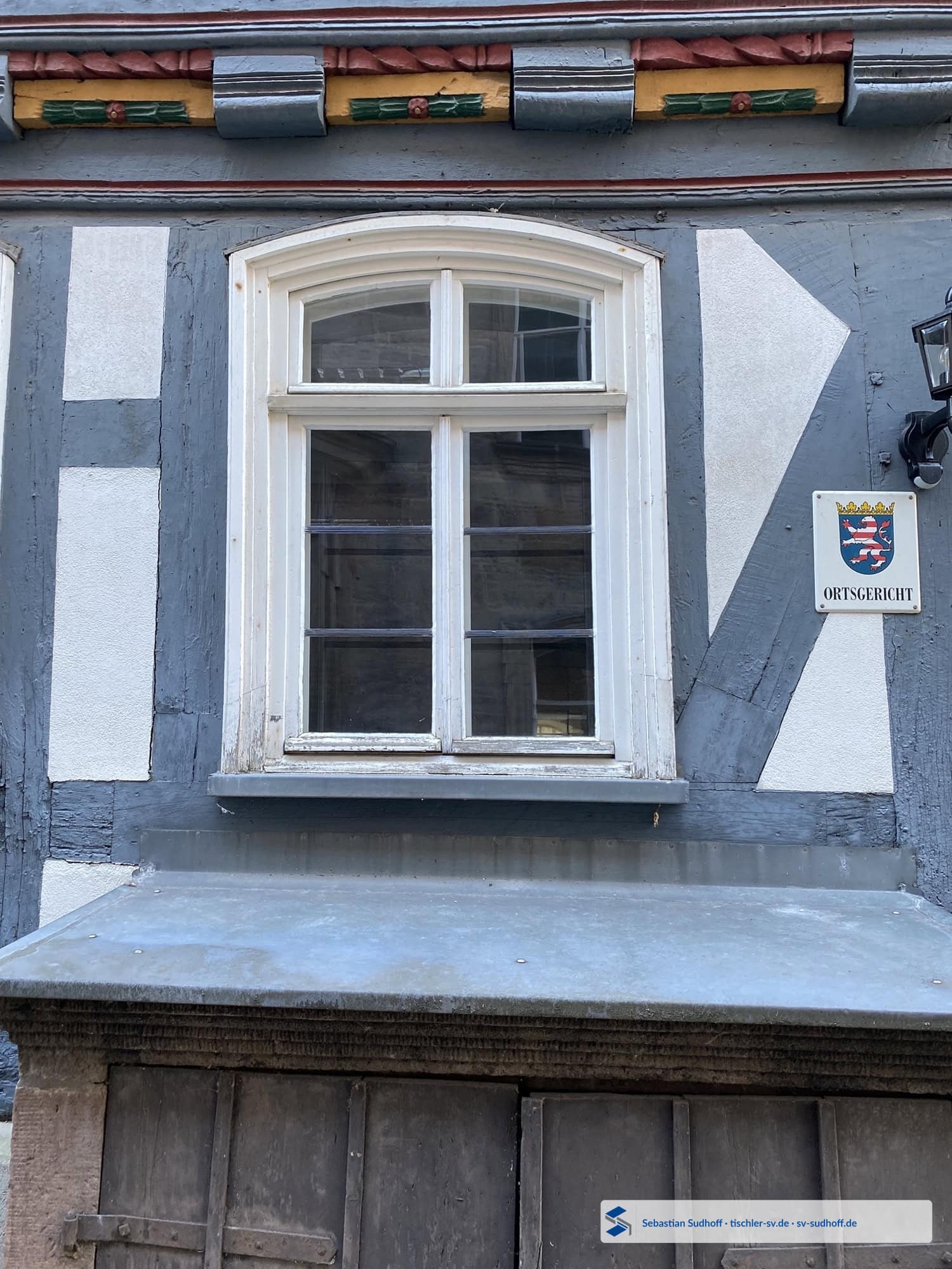 Bündig im Fachwerk montiertes Fensterelement mit bereits repariertem unteren Holzanschluss