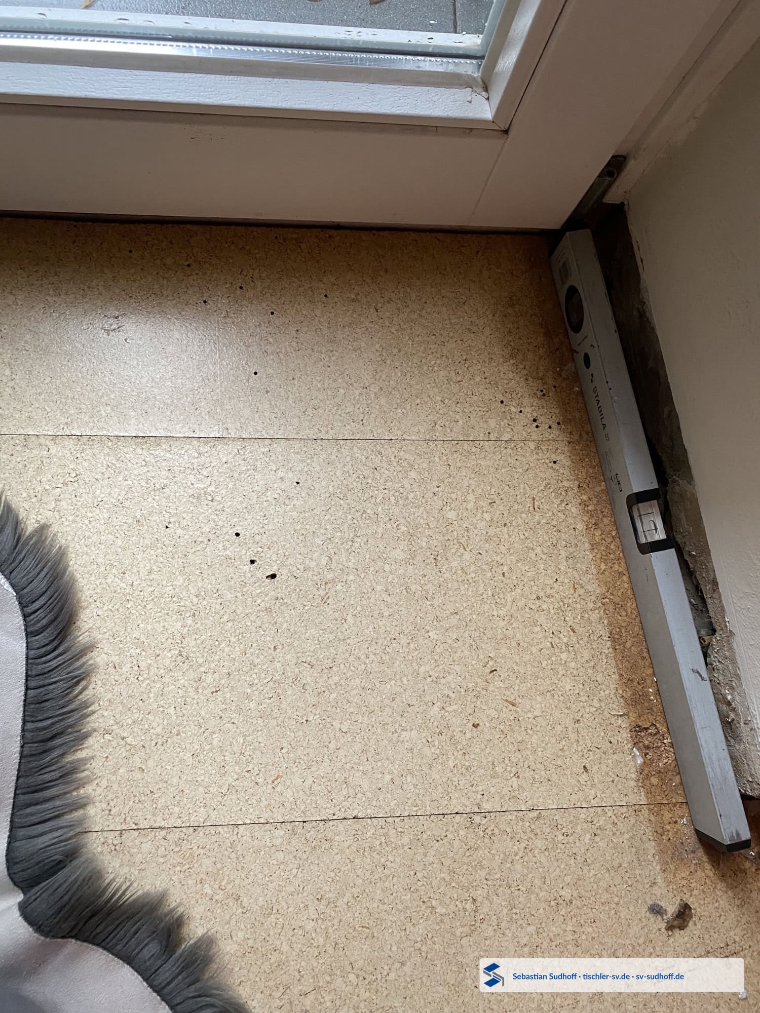 Löcher im Korkfußboden im Bereich des angrenzenden Fensteranschlusses