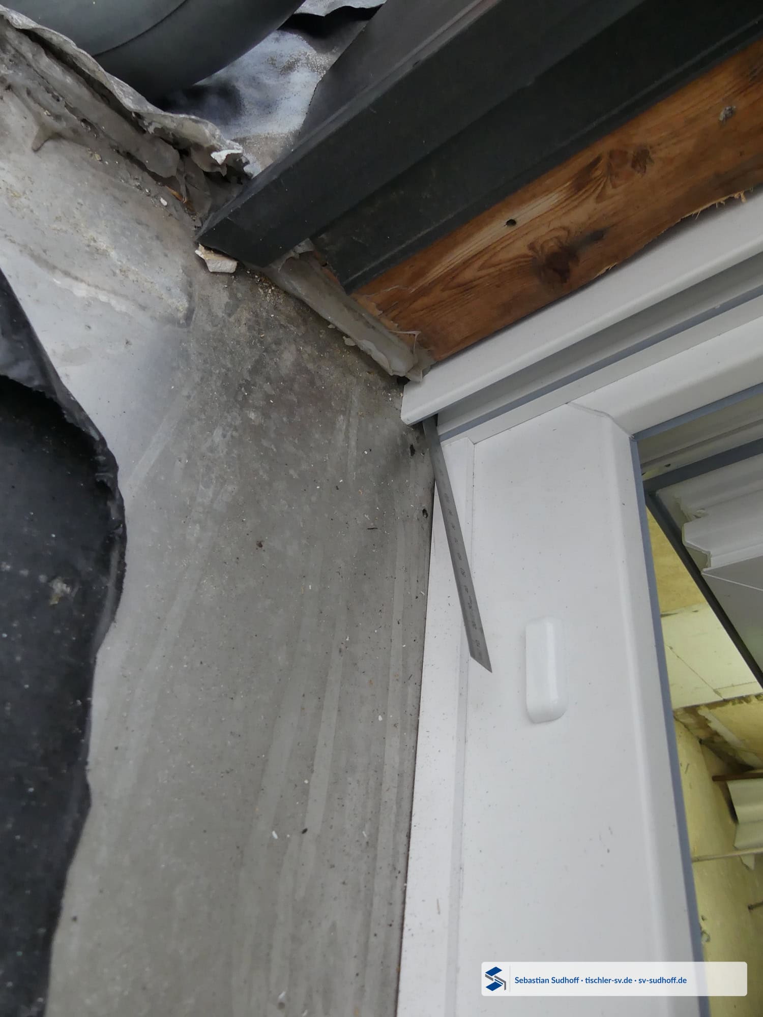 Übersicht des offenen Fensterbankanschlusses an der Rollladenführung mit Lineal in der Öffnung