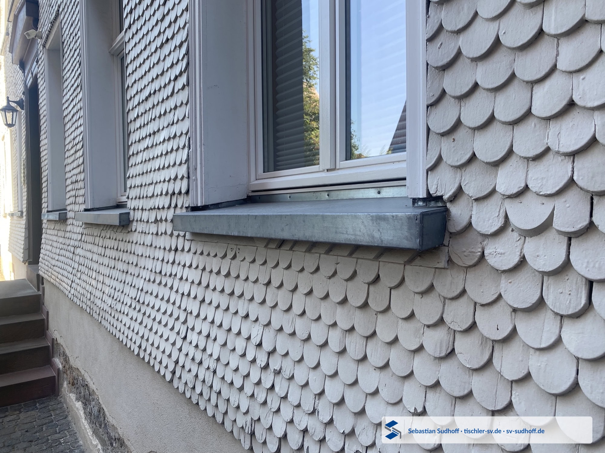 Oberer Fensteranschluss in einer Schindelfassade mit konstruktiver Wasserableitung