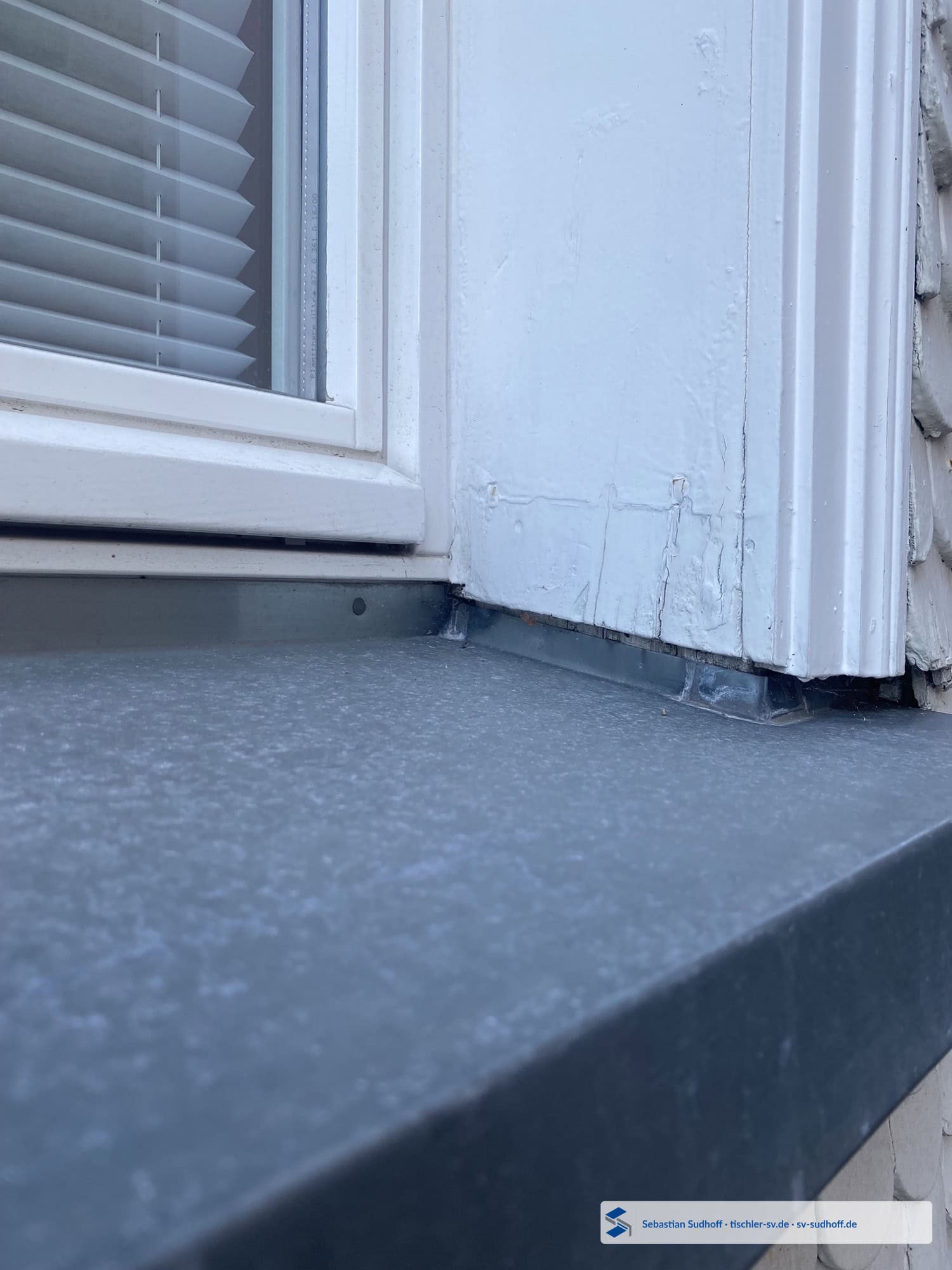 Seitliche Fensterwange einer Schindelfassade mit freier Wasserableitung zur Fensterbank