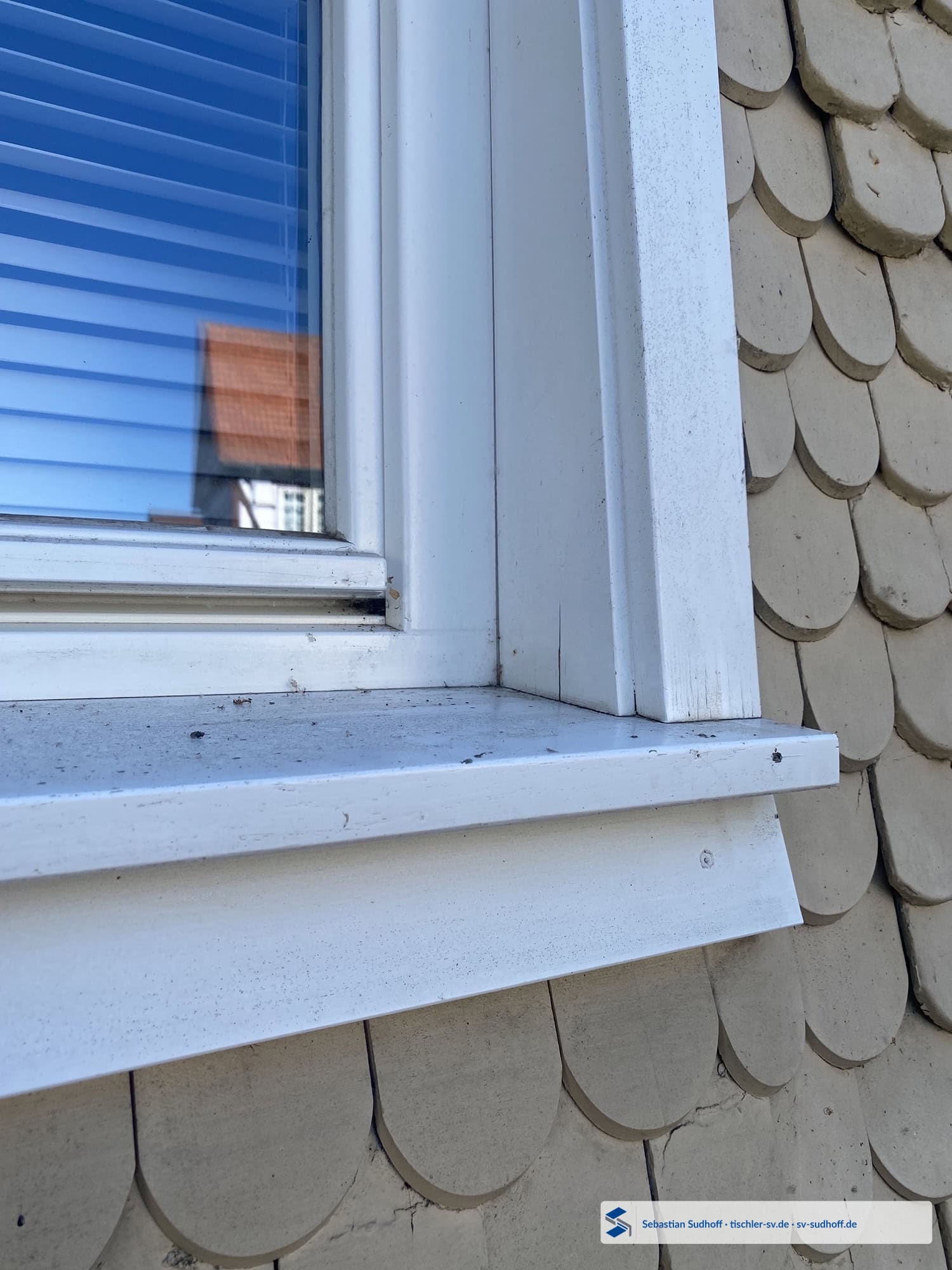 Beginnender Feuchteschaden am unteren Futter eines Holzfensters