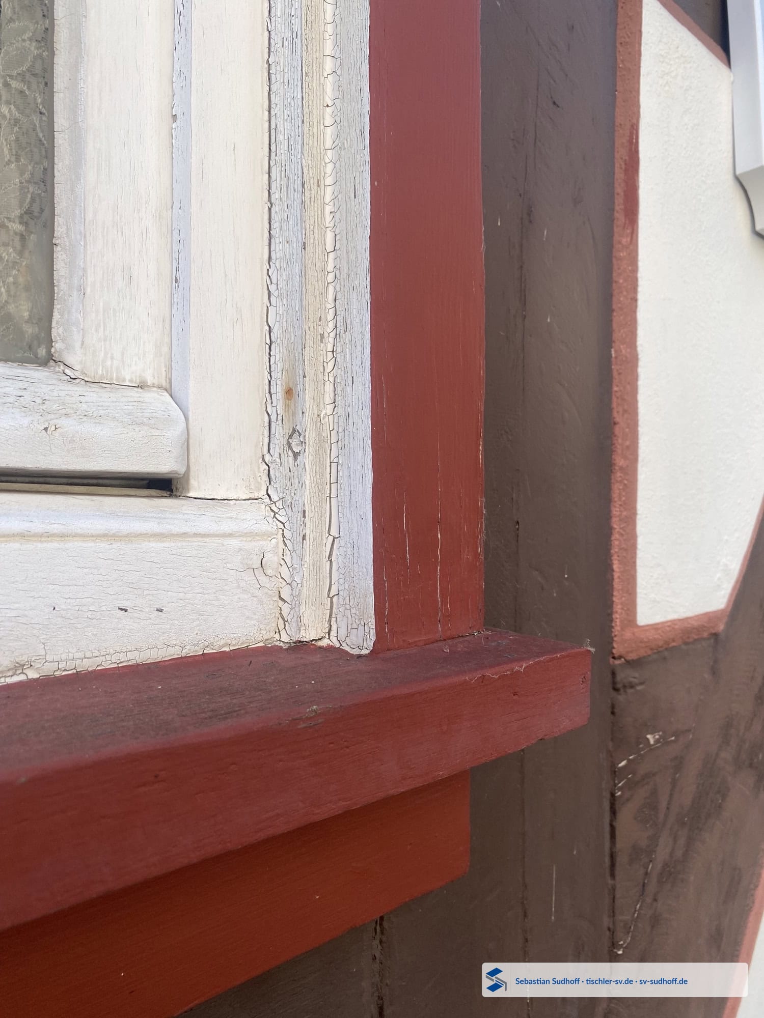 Älteres Holzfenster unter einem schützenden Dachüberstand