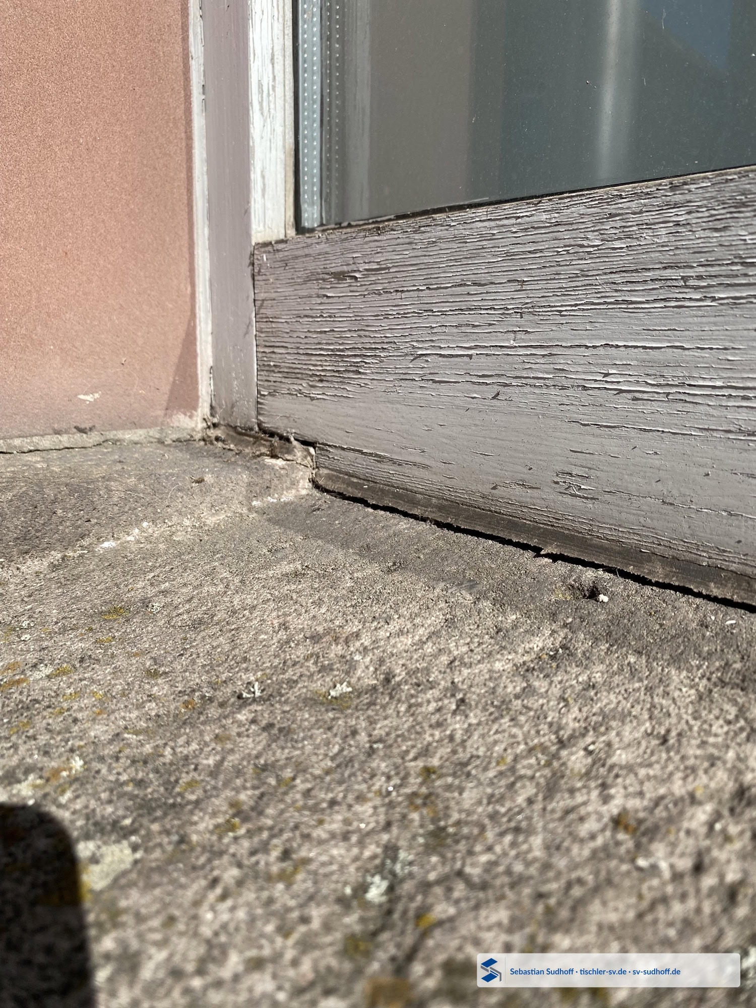 Alter Fensteranschluss mit Steinfensterbank und gealterter Dichtstofffuge