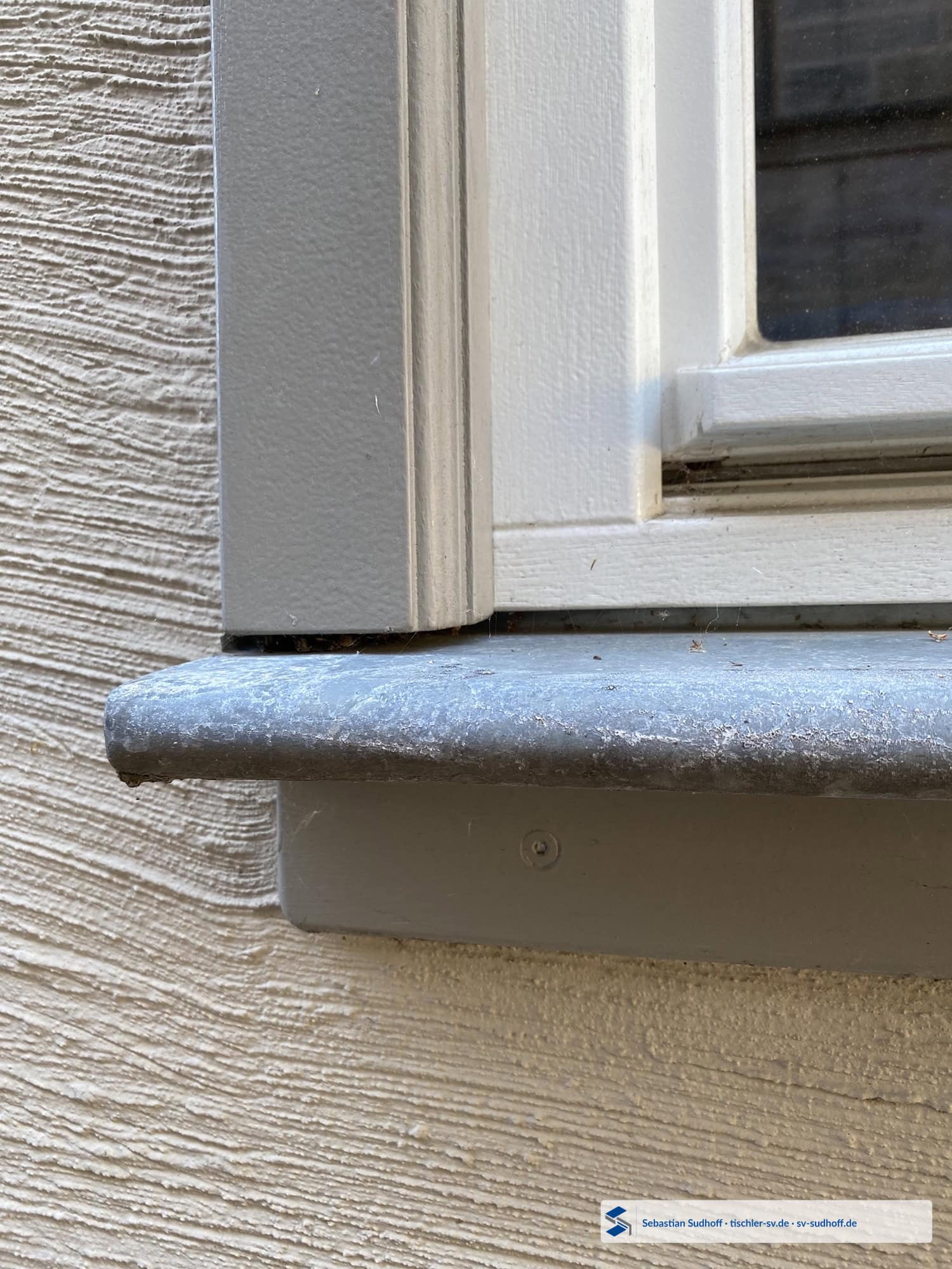 Holzfensterfutter mit schrägem unterem Abschluss über einer Fensterbank